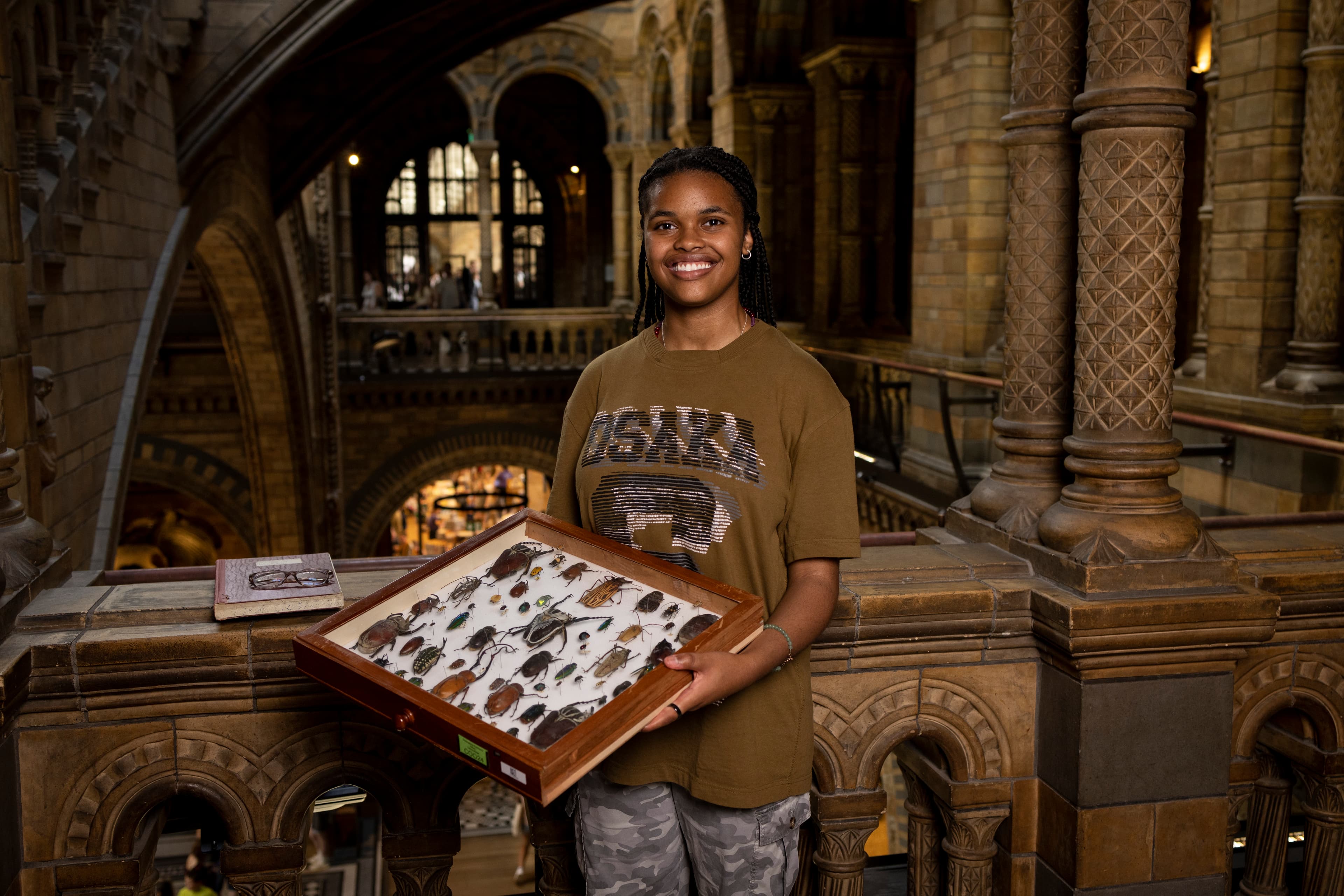 Student holding display case of bugs at Natural History Museum