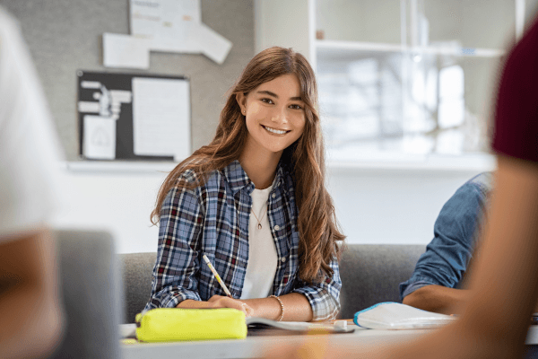 Smiling college student studying in classroom